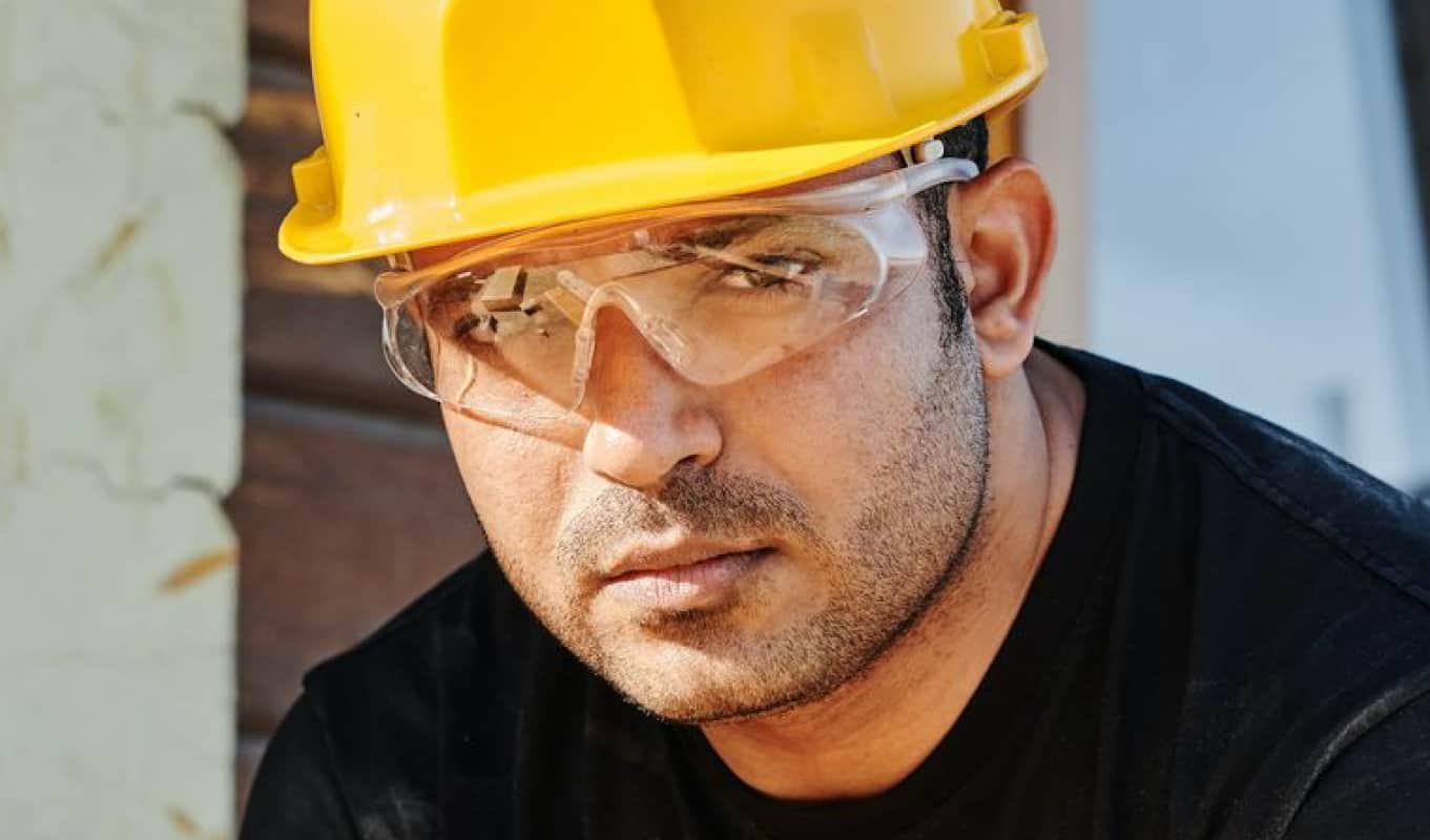 a person with glasses and a yellow hard hat looking at front