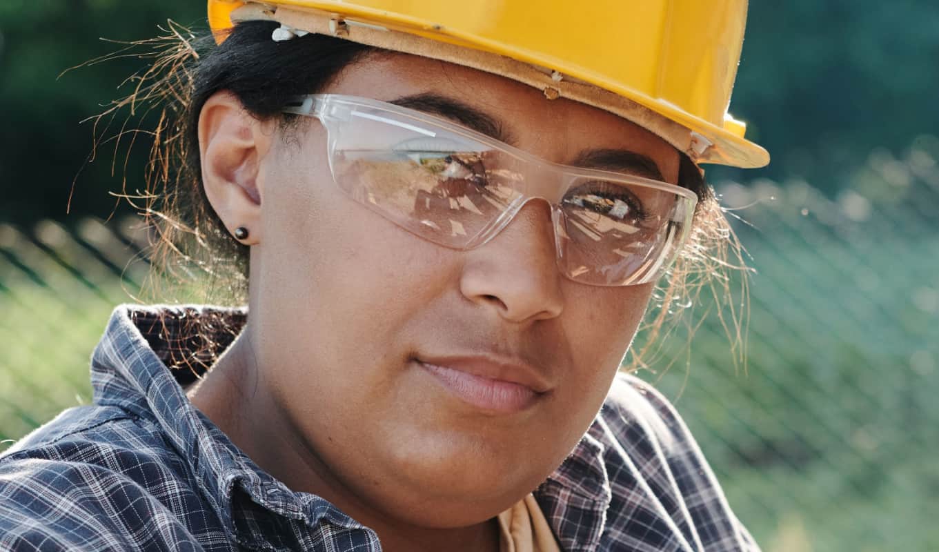 a person wearing safety glasses and a hard hat while standing outside